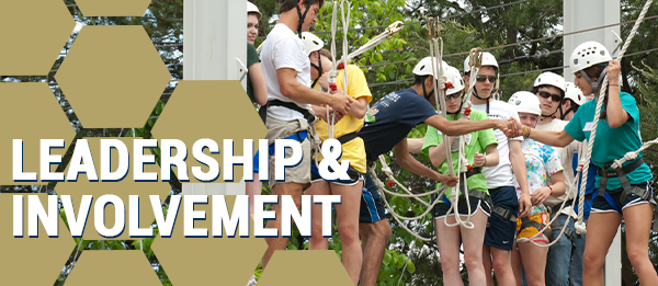 Photo of female and male students on ropes course.