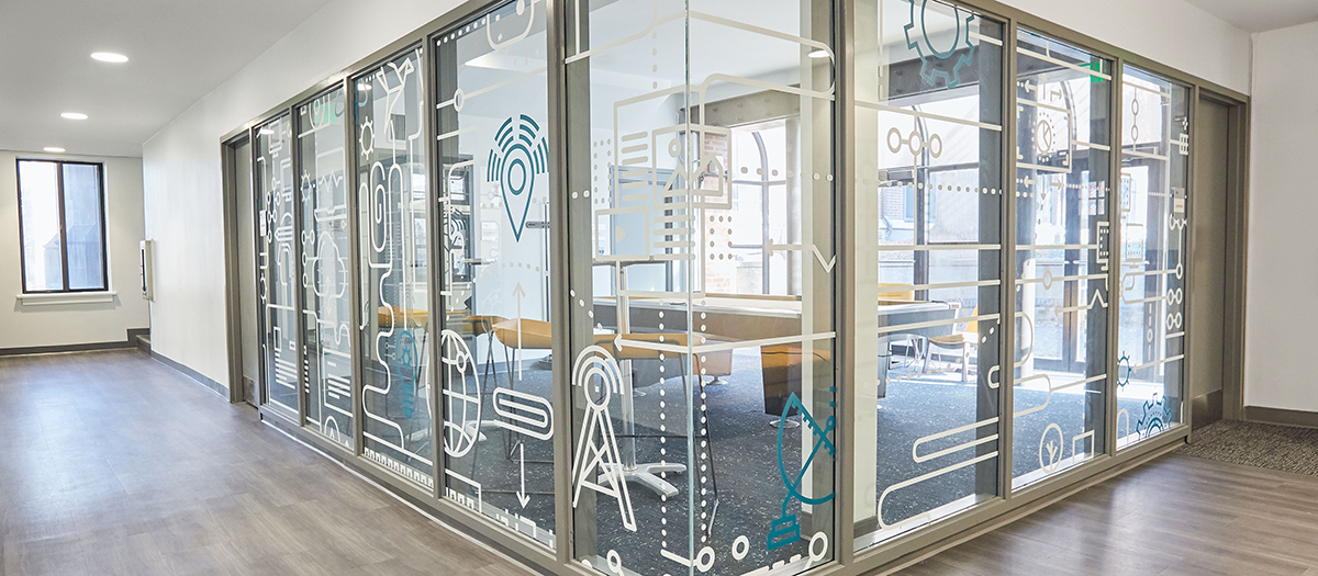 Glass wall with engineering and technology icons drawings.
