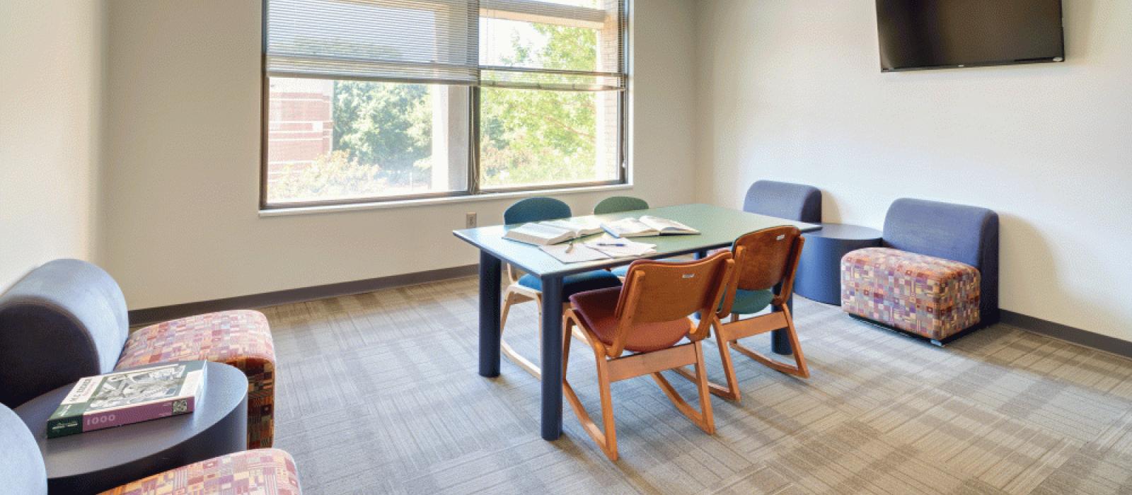 Study room: Table with 4 chairs, double windows and 2 sets of chairs with tables.