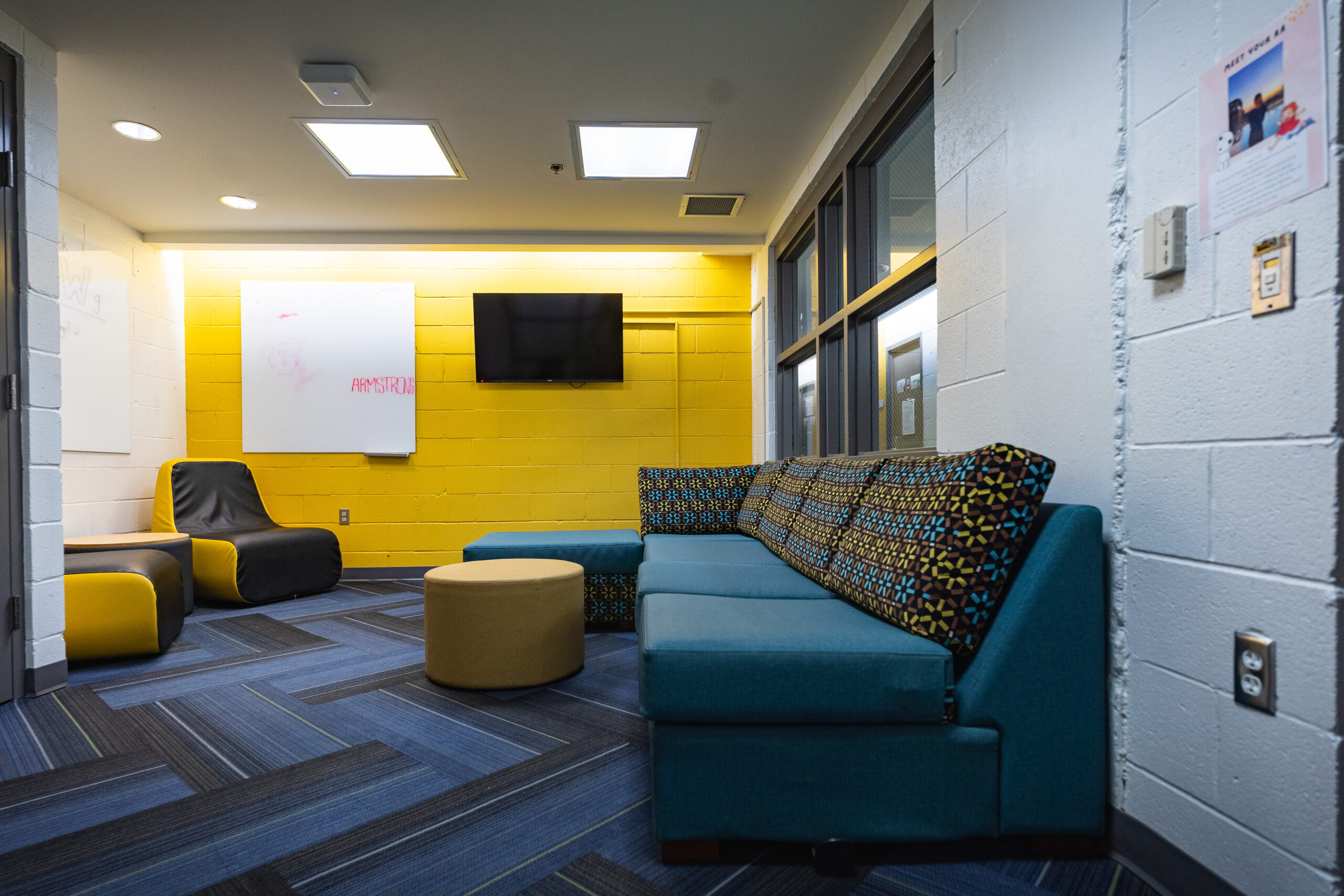 Lounge with couch, television, ottoman and individual seating chair